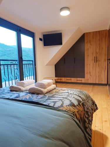a bedroom with a large bed with a view at Drina Escape - Lake View in Višegrad