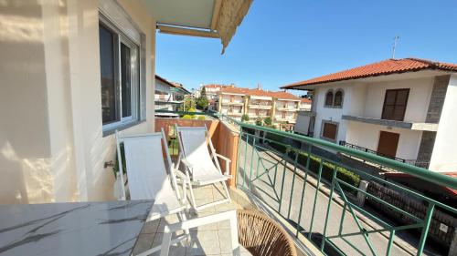a balcony with two white chairs on a building at Keremidis Apartment in Flogita