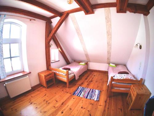 a attic room with two beds and a window at Siedlisko Szwałk in Szwalk