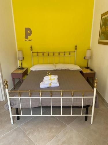 a bedroom with a bed with a yellow wall at Affittacamere Point Concept Rooms in Laurito