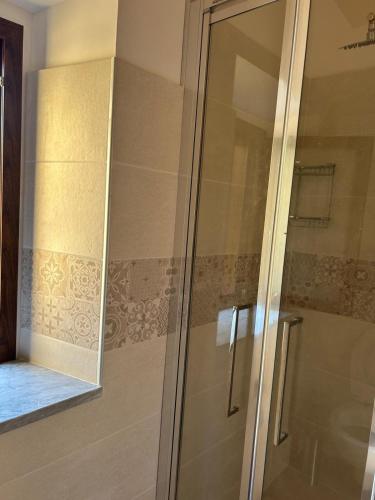 a shower with a glass door in a bathroom at Affittacamere Point Concept Rooms in Laurito
