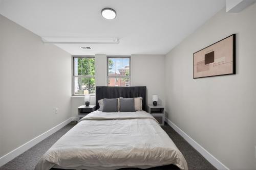 a white bedroom with a bed and two windows at Sleek 2BR apartment in prime location in Reading