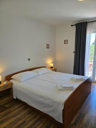 a bedroom with a large bed with two towels on it at Villa Castelana in Barbat na Rabu