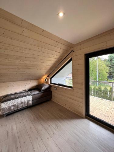 a room with a bed and a large window at Domki Albertówka - Strefa Relaksu in Ostrowo