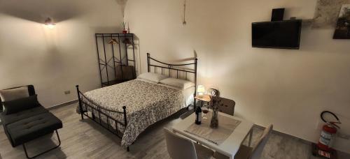a bedroom with a bed and a chair and a desk at Casa Italiannebrasille in Castellana Grotte