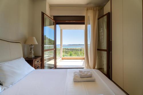 a bedroom with a bed with a view of the ocean at Villa Malvina in Neos Marmaras