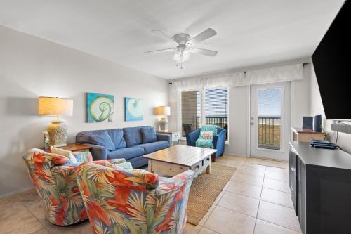 a living room with a blue couch and a table at Edgewater Condo Unit #304 in South Padre Island
