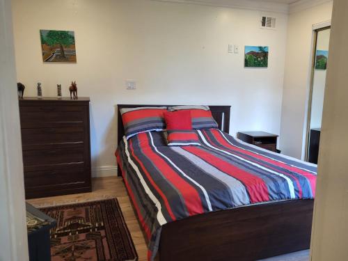 a bedroom with a bed with a colorful striped blanket at Guest house in Tujunga