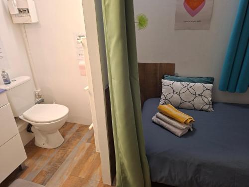 a small bathroom with a bed and a toilet at Le jardin secret in Uchaud