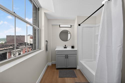 a white bathroom with a sink and a mirror at Elegant 2BR apartment with updated kitchen in Reading