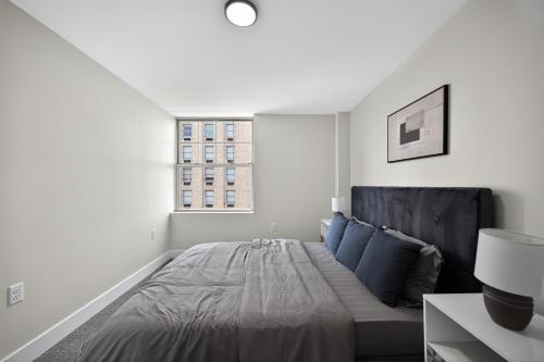 a white bedroom with a bed and a window at Elegant 2BR apartment with updated kitchen in Reading