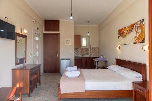 a bedroom with a large bed and a kitchen at NIKOS DIMAS STUDIOS in Parga