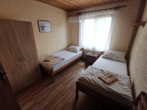 a small room with two beds and a window at Guest House Dijana in Kraljevica