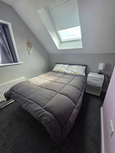 a bedroom with a large bed with a skylight at Guest House in Highbridge