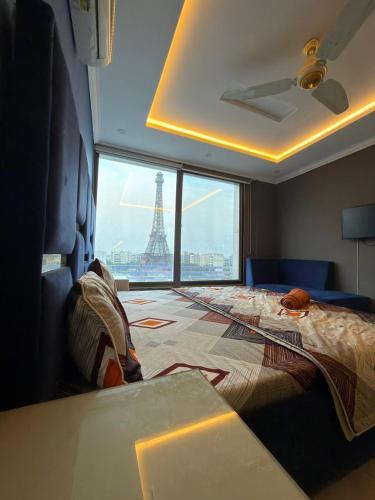 a bedroom with a bed with a view of the eiffel tower at Maison Eleve Residency in Lahore