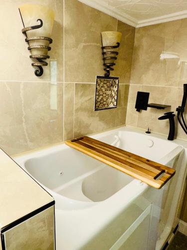 a bathroom with a white tub with lights on the wall at The Get Away Haven in Stockbridge