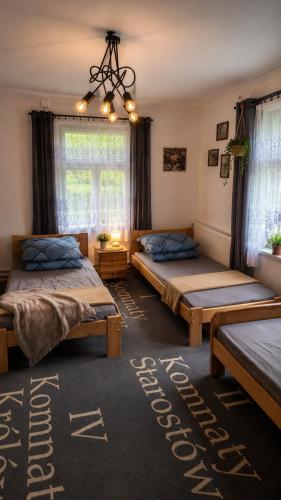 a bedroom with two beds and a chandelier at Agroturystyka całoroczna Ranczo Husinka in Husinka