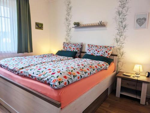 a bedroom with a large bed with a colorful comforter at Dümmernest in Hüde