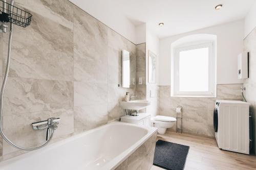 a bathroom with a tub and a sink and a toilet at Altmarkt Palais in Löbau