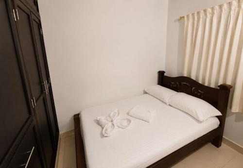 a small bed with white sheets and a bow on it at Casa hostal la herradura in San Vicente de Chucurí