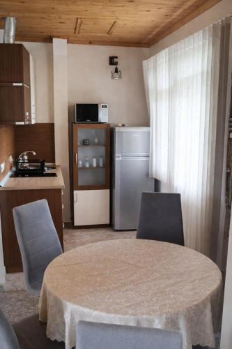 a kitchen with a table and chairs and a refrigerator at Къща Мариела in Sinemorets