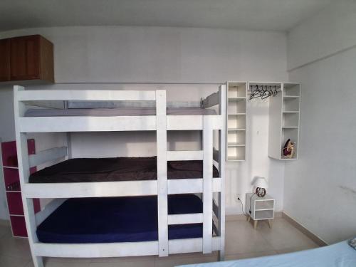 a bedroom with two bunk beds in a room at Guarapari com elevador, reformado, Wi-Fi, TV com Smart, vista livre e estacionamento in Guarapari