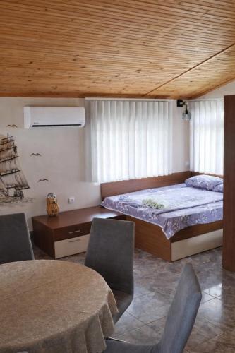a bedroom with a bed and a table and chairs at Къща Мариела in Sinemorets