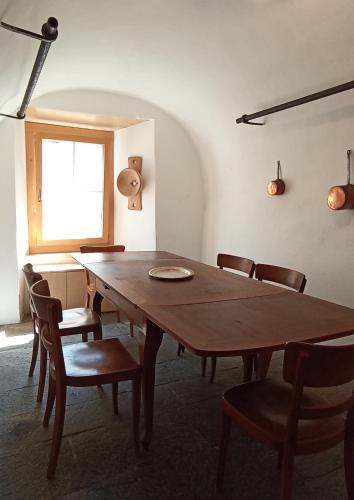 a dining room with a wooden table and chairs at Im Laret, Lavin in Zernez