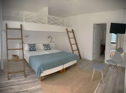 a bedroom with a bunk bed and a chair at Sunrise House 26 in Ponta Delgada