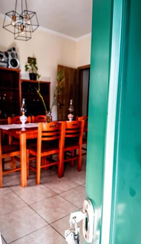 ein Esszimmer mit einem Tisch und Holzstühlen in der Unterkunft Dinis Hill in Tragána