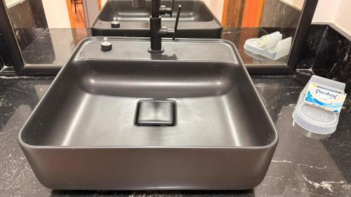 a metal counter top with a sink in a kitchen at Confortável 1 Quarto Ar Wi-fi Garagem in Vitória