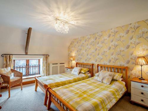 a bedroom with two beds and a chandelier at 3 Bed in Langport oc-76372 in Drayton