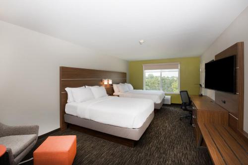 a hotel room with two beds and a flat screen tv at Holiday Inn Express Hastings by IHG in Hastings