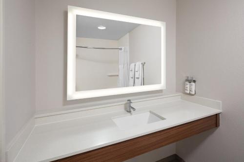 a bathroom with a white sink and a mirror at Holiday Inn Express Hastings by IHG in Hastings