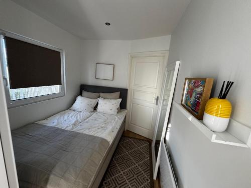 a small bedroom with a bed with a window at Hammar Hus in Kristianstad