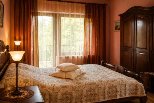 a bedroom with a bed and a window at Adomo Rojus in Palanga