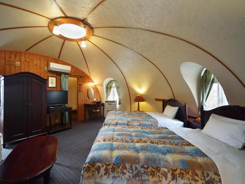 a bedroom with a large bed with an arched ceiling at Aso Farm Land in Minami Aso