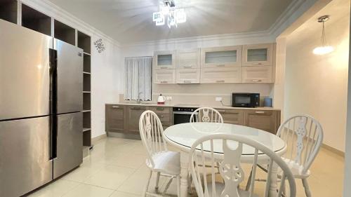 a kitchen with a table and chairs and a refrigerator at sliema promenade in Sliema