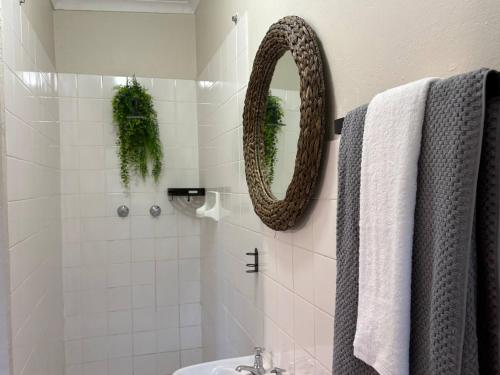 a bathroom with a shower with a mirror and a sink at Accommodation at Klein Street-Blue in Paarl