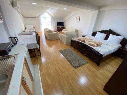 a bedroom with a large bed and a living room at Hotel Venecia Apartments in Struga