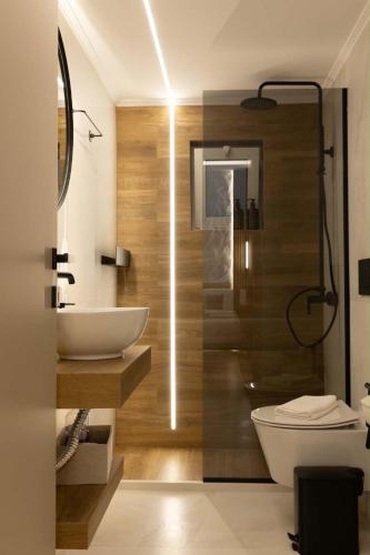 a bathroom with a white sink and a toilet at Charma Urban Living in Bendevís