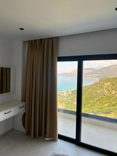 a room with a large window with a view of the ocean at Borsh sunset apartments in Borsh