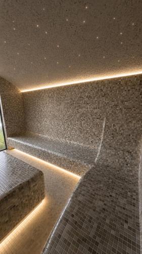 a bench in a room with a brick wall at Aura Glemp & SPA in Laukbeitini