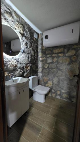 a stone bathroom with a toilet and a sink at Mini Garden PREMIUM in Mojkovac