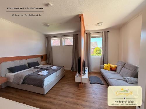 a bedroom with a bed and a couch at Heideglück Soltau - Ferienwohnungen An der Weide in Soltau