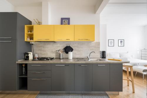 a kitchen with gray cabinets and a sink at Canonica Suites in Bologna