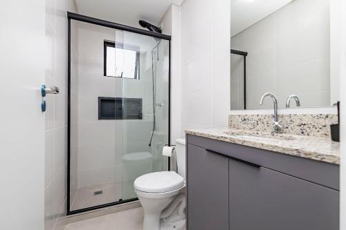 a bathroom with a toilet and a glass shower at Cabral Smart Comfort in Curitiba
