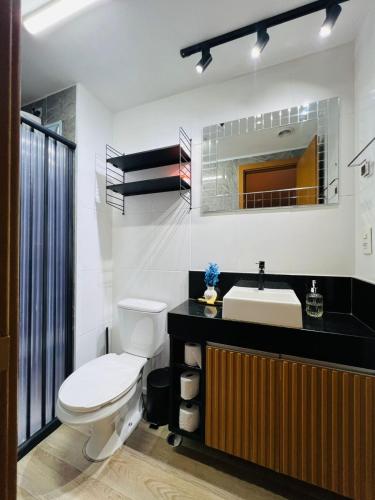 a bathroom with a toilet and a sink at Flat 701 in Guarulhos