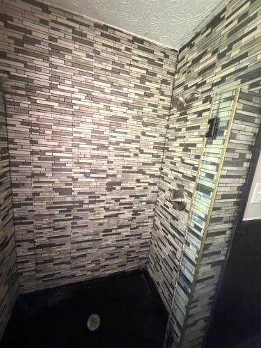 a bathroom with a shower with brick walls at April Palace green in Decatur