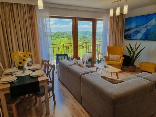 a living room with a couch and a table and chairs at Apartamenty Kaniówka 25 in Gliczarów Górny